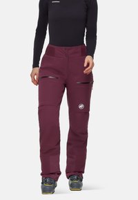 Maroon skidbyxor med en slät yta, som har två fickor med dragkedja och en broderad logotyp. Avsmalnande passform med förstärkt nederkant.