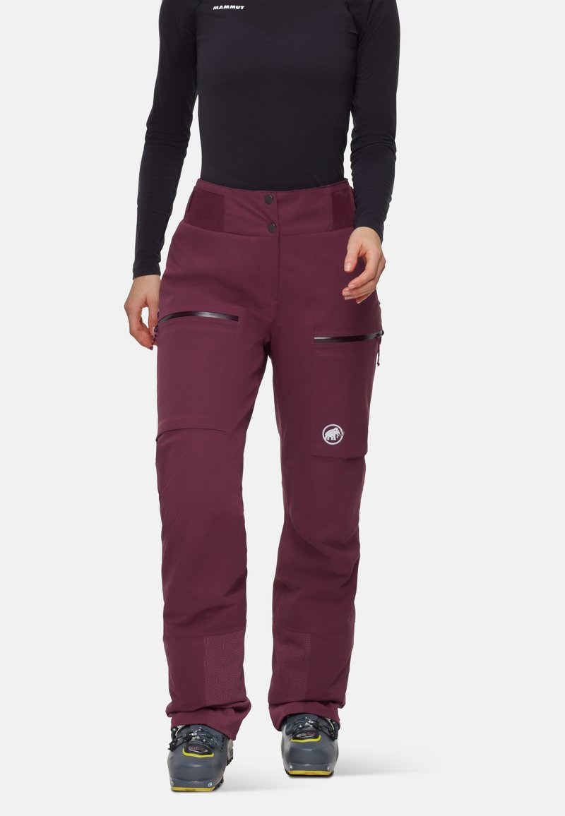 Maroon skidbyxor med en slät yta, som har två fickor med dragkedja och en broderad logotyp. Avsmalnande passform med förstärkt nederkant.