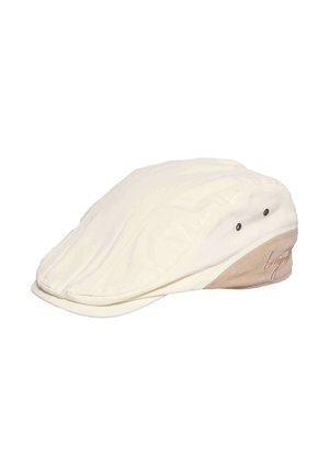 Cream-colored flat cap with beige side panel and two ventilation eyelets, featuring embroidered script detail on the side.