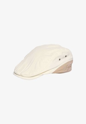 Cream-colored flat cap with beige side panel and two ventilation eyelets, featuring embroidered script detail on the side.