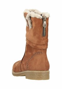 Bruine suède enkelboot met een zachte binnenvoering, een zijrits en een gestructureerde zool. Kenmerkt zich door gestikte details nabij de zool.