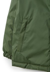 Giacca imbottita verde, con una tasca laterale, orlo elastico e texture liscia e lucida. Il design è voluminoso con una forma slanciata.