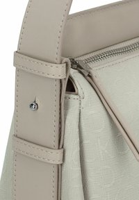 Borsa a tracolla in pelle beige chiaro con un motivo tessuto a trama, chiusura lampo in argento e una tracolla robusta con dettagli di cucitura.