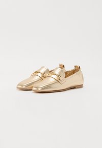 Mocassins métalliques dorés avec un bout pointu, mettant en avant une sangle décorative à boucle et un design minimaliste. Surface lisse et talon bas.