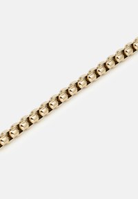 Bracelet en métal doré avec des maillons lisses et arrondis, reliés dans un motif continu, créant un design flexible et brillant.