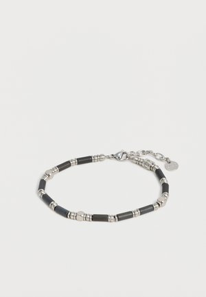 Zilveren en zwarte kralenarmband met cilindervormige en ronde kralen, karabijnsluiting en verstelbare ketting met klein merkteken.