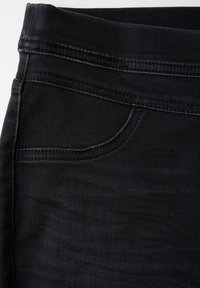 Svart denimkjol med en slät textur, femfickorsdesign och kontrastsömmar längs sömmarna. Medelhög midja ingår.