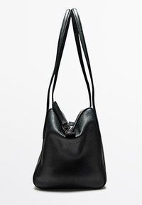 Borsa a mano in pelle nera con un design morbido e strutturato. Presenta due manici lunghi e una chiusura con zip nella parte superiore. Superficie testurizzata.