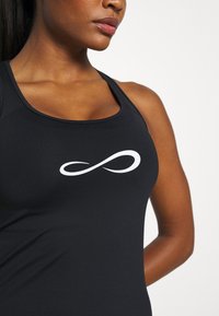 Débardeur de sport noir avec un logo symbole infini blanc. Tissu lisse avec une coupe ajustée et des accents en mesh au niveau des épaules.