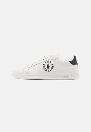 Zapatilla blanca baja Polo Ralph Lauren con logo negro y texto en el lateral, acento negro en el talón, diseño con cordones.