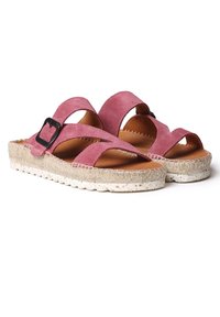 Pink suede sandals with a cross-strap design, black buckle detail, and a textured, natural woven sole.