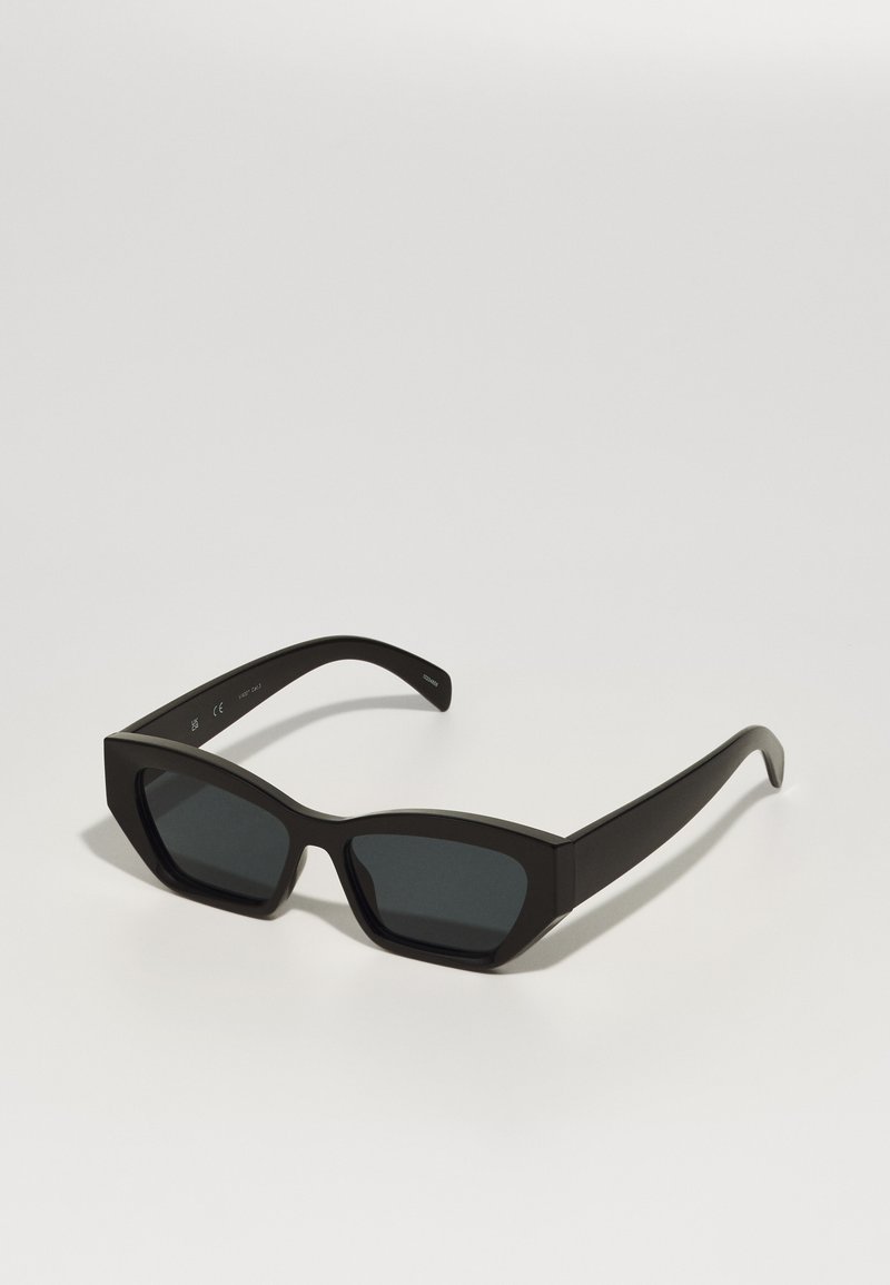 Ochelari de soare negri, dreptunghiulari, cu rame groase, lentile întunecate și un finisaj mat. Prezintă un design geometric și nu au marcaje de brand vizibile.