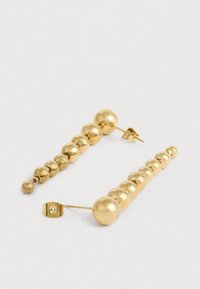 Χρυσές σκουλαρίκια που περιλαμβάνουν μια σειρά από λείους σφαιρικούς κόμπους διαφόρων μεγεθών, ταξινομημένους σε φθίνουσα σειρά σε στήριγμα.