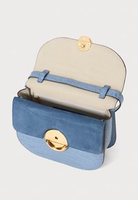 Blue handbag with a textured crocodile pattern and suede finish. Gold circular hardware, open with inner compartment and strap.