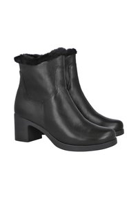 Botas de tobillo de cuero negro con un tacón bajo y ancho. Presentan un suave forro de piel negra alrededor de la parte superior. Textura lisa con mínima costura.