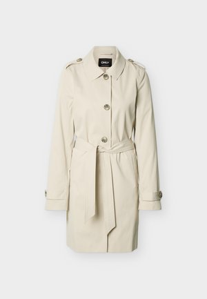 Μπεζ καμπαρντίνα μήκους μέχρι το γόνατο με κούμπωμα με κουμπιά, ζώνη μέσης, επιθεμάτων στους ώμους και ιμάντες στα μανίκια, παρουσιασμένη σε απλό φόντο.