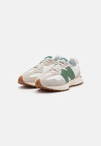 Sneakers with a beige suede and white leather upper, featuring green accents, textured rubber sole, and round toe design.