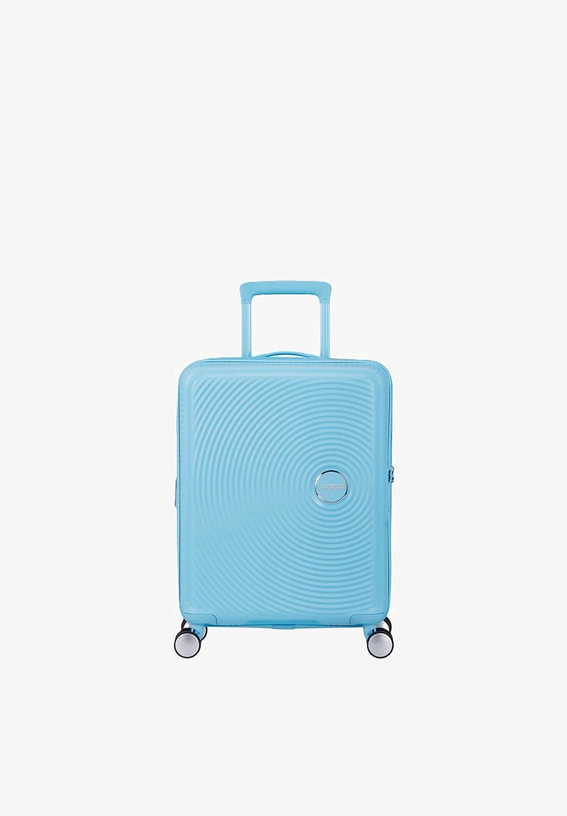 Valise rigide bleu clair avec un motif de cercles concentriques, poignée télescopique et quatre roues pivotantes.