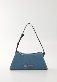 Bolsa de denim azul com formato triangular, alça de couro preto, fecho superior em zíper e detalhe em prata com o logótipo na frente.