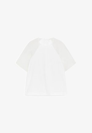 Blouse blanche à manches courtes avec tissu transparent aux épaules, encolure ronde et fermeture éclair au dos.