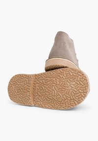 Stivaletti in suede grigi con punta rotonda e suola in gomma testurizzata, con una suola beige dotata di un grip a motivo.