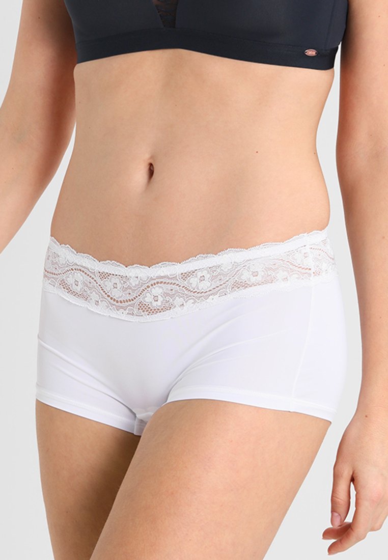 Hvite stoffshorts med blondeelastikk i livet som har et blomstermønster. Glatt tekstur; tettsittende design; midjehøyde.
