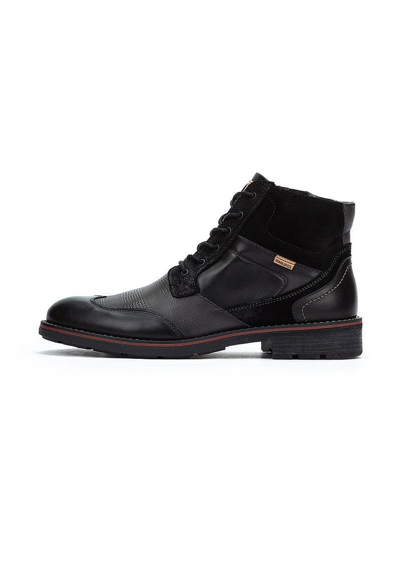 Stivali alla caviglia neri realizzati con materiali misti: pelle liscia e suede texture. Presentano un design con lacci, dettagli cuciti e una suola in gomma.