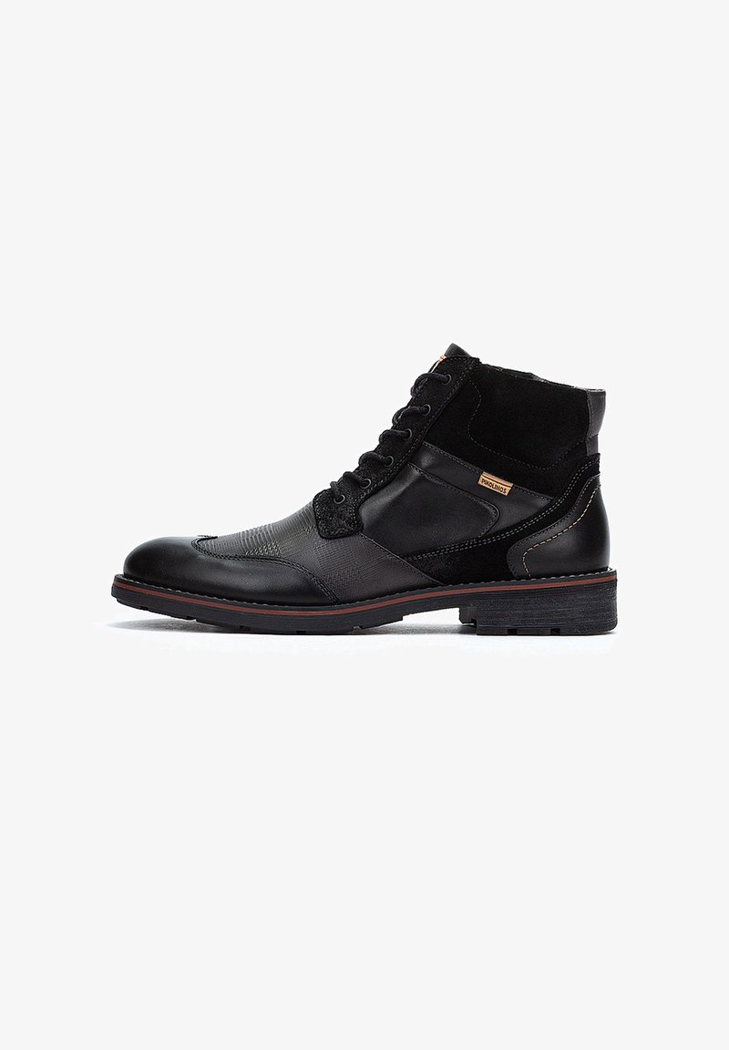 Stivali alla caviglia neri realizzati con materiali misti: pelle liscia e suede texture. Presentano un design con lacci, dettagli cuciti e una suola in gomma.