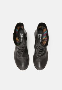 Botas de cuero negras hasta el tobillo con un diseño holgado, que presentan una superficie texturizada y un forro interior estampado en colores vibrantes.