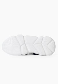 Suola di sneaker bianca con motivi geometrici di battistrada che includono triangoli e trapezi, mostrata dal basso su uno sfondo bianco.