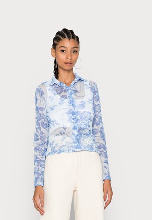 Blusa floral transparente em azul claro, com fecho de botões à frente, colarinho pontudo e mangas compridas. Padrão floral decorativo em vários tons de azul.