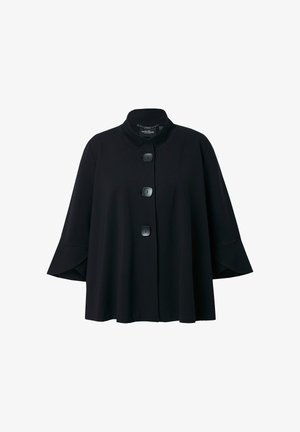 Musta lyhyt takki, jossa on kolme suurta neliönmuotoista nappia ja leveät hihat, korkea kaulus ja löysä istuvuus.