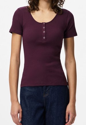 Viininpunainen ribbineuloksinen lyhythihainen toppi, jossa on pyöreä pääntie ja edessä nappidetalji, valmistettu pehmeästä ja joustavasta materiaalista.