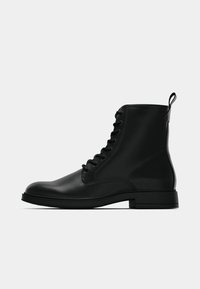 Stivali alla caviglia in pelle nera con lacci, dalla finitura liscia, punta rotonda, suola robusta e una piccola linguetta sul retro per una facile calzata.