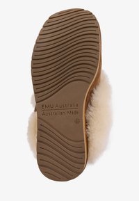 Suela de pantufla de ante marrón con un patrón de huella ondulada, forro de suave piel de oveja blanca y una marca en relieve que dice "EMU Australia Australian Made."