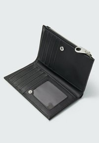 Portefeuille en cuir noir avec plusieurs emplacements pour cartes, une fenêtre ID transparente et une section zippée, présentant une texture lisse et un design minimaliste.