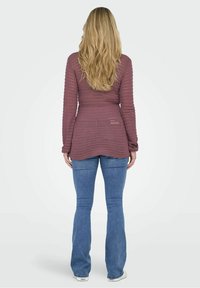 Jean évasé et haut à manches longues côtelé de couleur mauve doux, avec un tissu texturé et un ourlet incurvé à l'arrière.