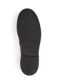 Suola nera in gomma di una scarpa con motivo di presa testurizzato, forma arrotondata e design minimalista. Nessun segno o accento visibile.