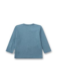 Himmelblaues Langarmshirt aus Baumwolle. Mit rundem Halsausschnitt und gesteppten Säumen, mit einem Etikett an der Seite. Sanfte Textur.