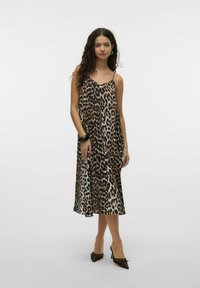 Abito sottoveste con stampa leopardata, spalline sottili, una silhouette fluida e una texture setosa; tonalità di marrone, beige e nero dominano il motivo.