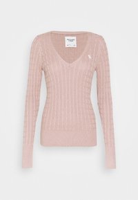 Lichtroze, geribbelde breiselsweater met een V-hals, lange mouwen en een aansluitend ontwerp. Beschikt over een klein logo op de linkerborst.