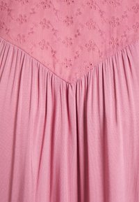 Vestido rosa com padrões florais bordados no corpete, com uma saia plissada franzida e uma textura suave por toda a peça.
