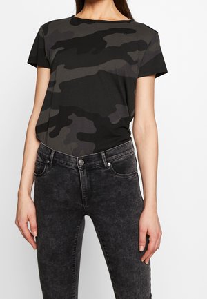 T-shirt camouflage noir et gris à manches courtes et col rond, associé à un jean en denim noir avec une texture délavée et des poches avant.