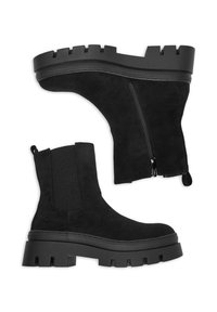 Botas de tobillo de ante negro con suela de goma gruesa, que cuentan con un cierre lateral y un panel elástico para facilitar su uso. Parte superior texturizada, acabado mate.