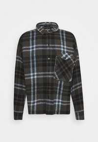 Camisa de franela a cuadros en negro y gris con acentos azules, de manga larga, con cierre de botones en el frente y un bolsillo en el pecho. Textura suave y corte holgado.