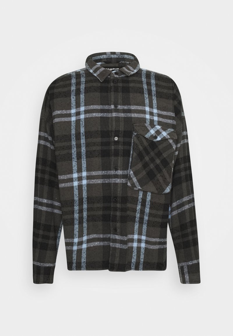 Camisa de franela a cuadros en negro y gris con acentos azules, de manga larga, con cierre de botones en el frente y un bolsillo en el pecho. Textura suave y corte holgado.