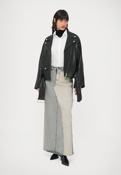 Casaco de motociclista cropped em couro preto, camisa branca, saia de patchwork em ganga cinzenta e clara, botas pretas pontiagudas até ao joelho, textura lisa, design em camadas.