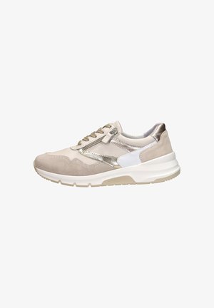Beige suede sneaker with metallic accents and white detailing. Features lace-up closure, textured panels, and a cushioned sole.