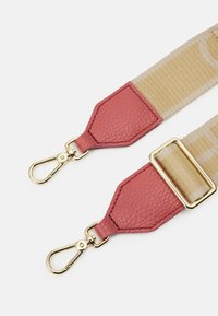 Regulowany pasek do torby z różowymi, fakturowanymi skórzanymi końcówkami, złotymi elementami i kontrastującym beżowym, plecionym materiałem z subtelnym wzorem.