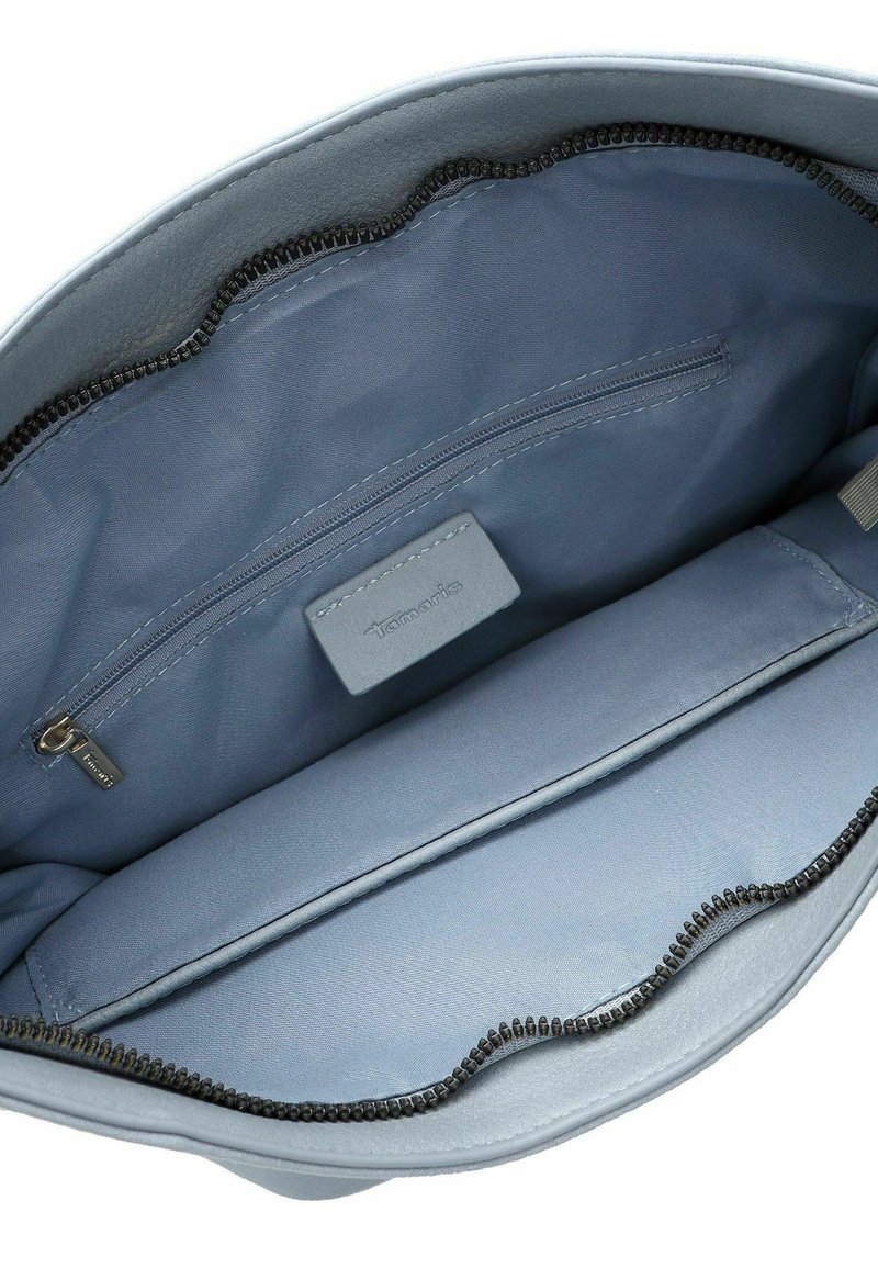 Intérieur d'un sac en cuir synthétique gris comportant une poche zippée et un compartiment plat ; texture lisse avec un bord de fermeture éclair ondulé.